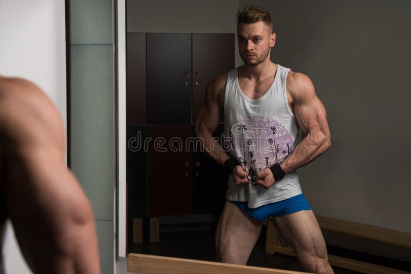 Мышечный человек изгибая мышцы в спортзале в Undershirt стоковое изображение rf