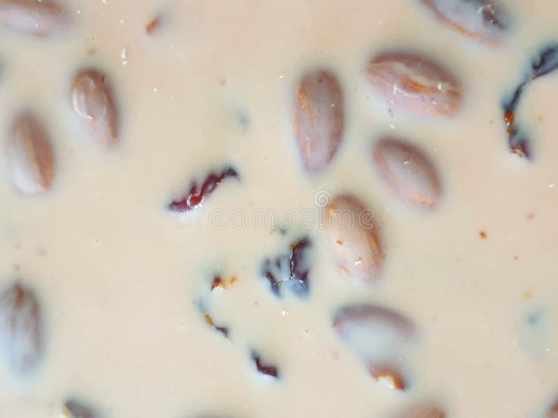 Мягкий фокус шоколадного батончика молока с миндалинами и изюминками как предпосылка стоковое изображение rf Мягкий фокус шоколадного батончика молока с миндалинами и изюминками как предпосылка стоковое изображение rf