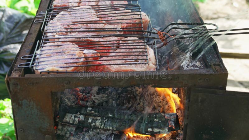 мясные стейки на гриль-стойке, приготовленные на открытом огне