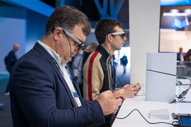 : На выставке Mobile World Congress 2025 люди тестируют умные очки или очки стоковая фотография rf