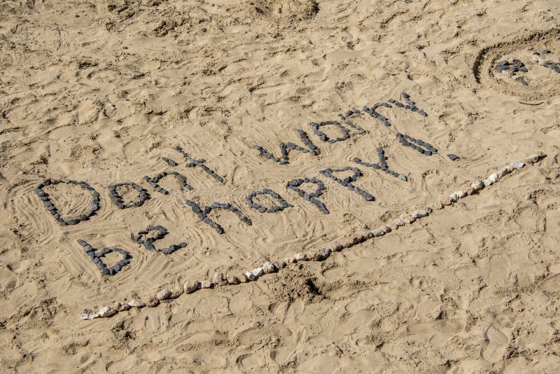 Don't Worry Be Happy, with stones in sand. Don't Worry Be Happy, with stones in sand.