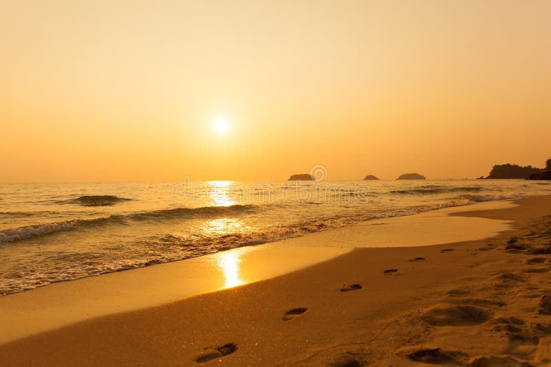 Beautiful sunset above the sea. Footprints in the sand. Beautiful sunset above the sea. Footprints in the sand