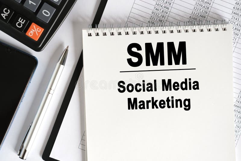На столе лежит смартфон калькулятор и ноутбук с smm надписи стоковая фотография
