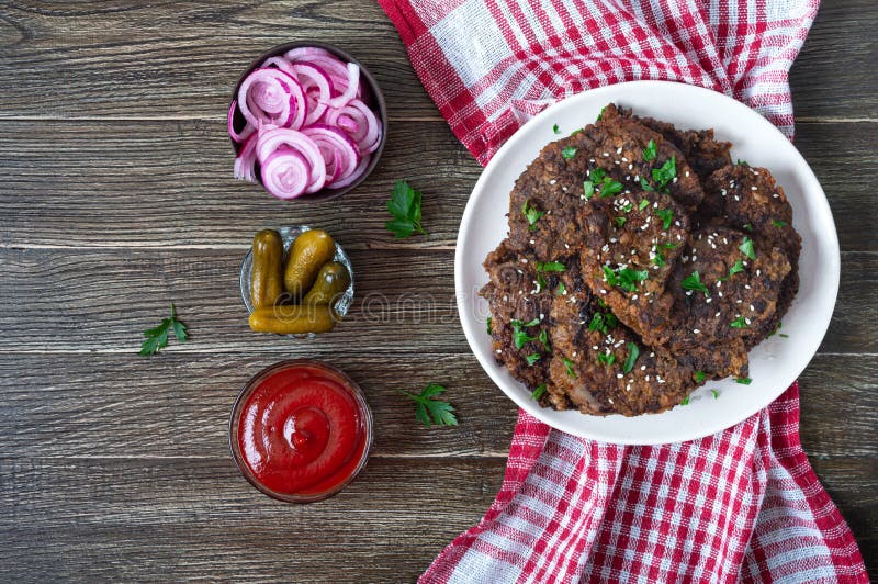 На части печени с томатным соусом замариновали лук и огурцы. Очень вкусное здоровые блюда. Вид сверху стоковое изображение rf