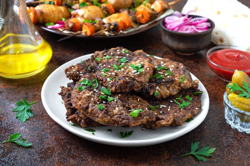 На части печени с томатным соусом замариновали лук и огурцы. Очень вкусное здоровые блюда стоковое изображение