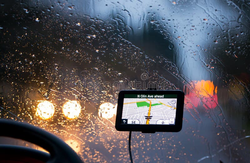 Навигатор GPS в фарах идя дождь стекла и taillights стоковая фотография rf Навигатор GPS в фарах идя дождь стекла и taillights стоковая фотография rf