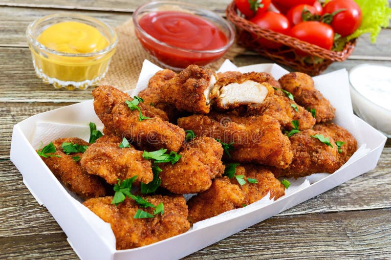 Наггеты цыпленка Части глубок-зажаренного кудрявого мяса, с различными соусами на деревянном столе стоковое фото rf