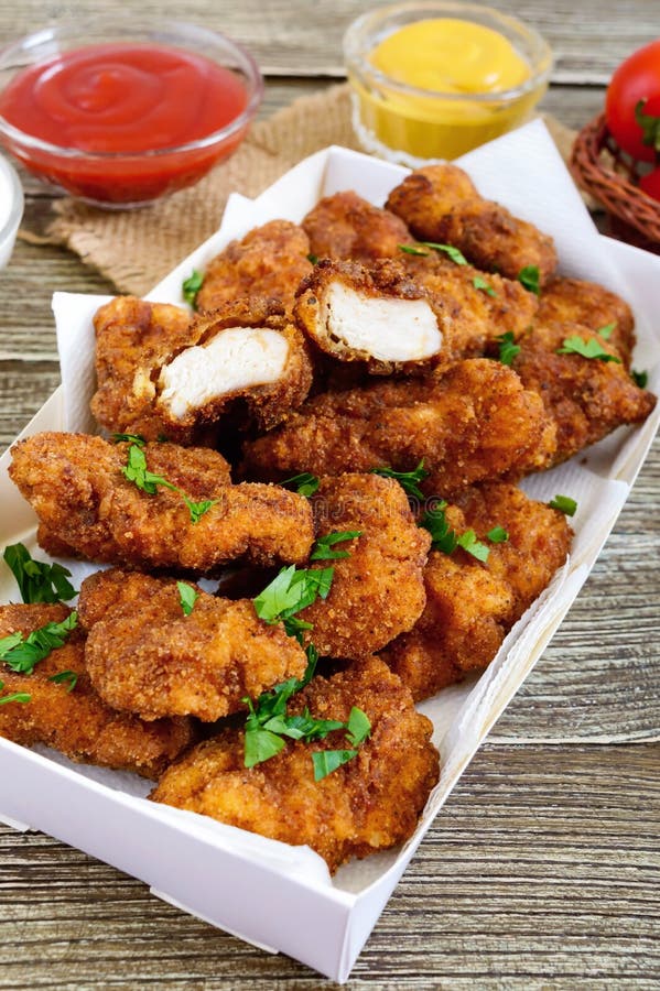 Наггеты цыпленка Части глубок-зажаренного кудрявого мяса, с различными соусами стоковое изображение