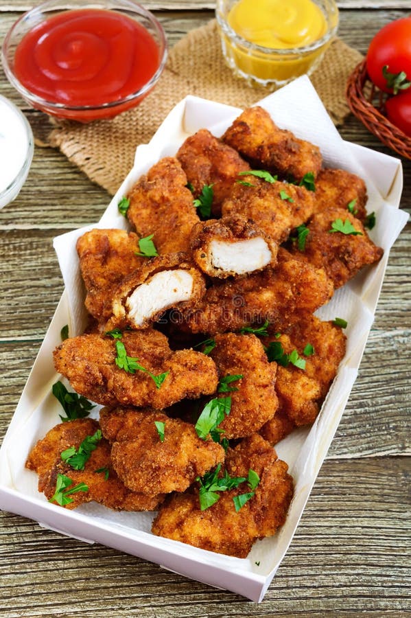 Наггеты цыпленка Части глубок-зажаренного кудрявого мяса, с различными соусами стоковые фотографии rf