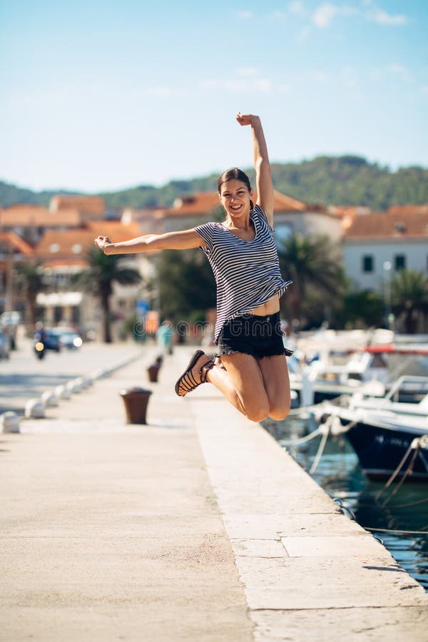 Over exited happy woman jumping in the air out of happiness.Vacation time concept.Seaside coastal vacation excitement.Woman in joy got good news.Rejoicing,full of life.Summer female active,energetic. Over exited happy woman jumping in the air out of happiness.Vacation time concept.Seaside coastal vacation excitement.Woman in joy got good news.Rejoicing,full of life.Summer female active,energetic