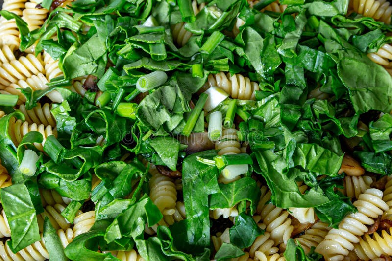 Надземный взорвать застрелили pasta fusilli крытых с луком весны шпината и сваренными с грибами стоковое изображение