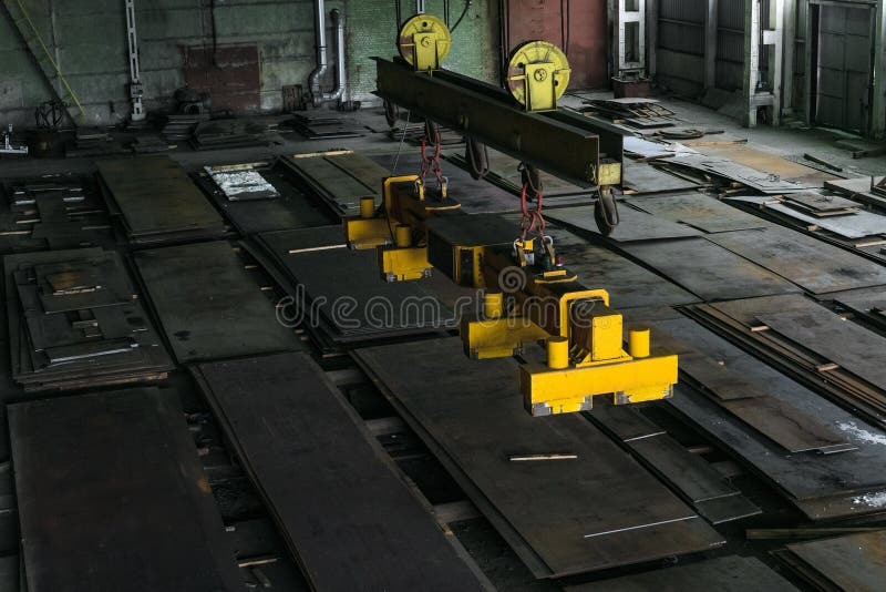 Надземный кран путешествовать с магнитными grippers траверсирует для поднимаясь стальных листов стоковые изображения