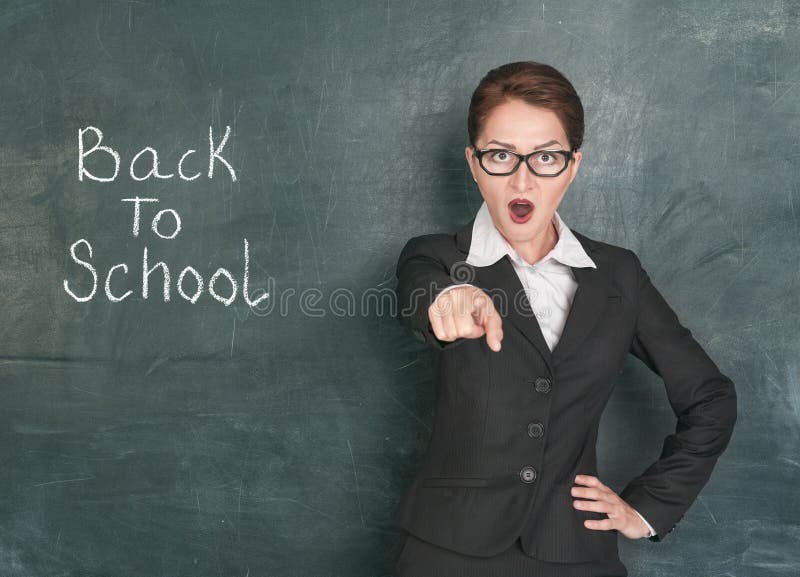 Screaming teacher on the school blackboard background with phrase Back to school. Screaming teacher on the school blackboard background with phrase Back to school