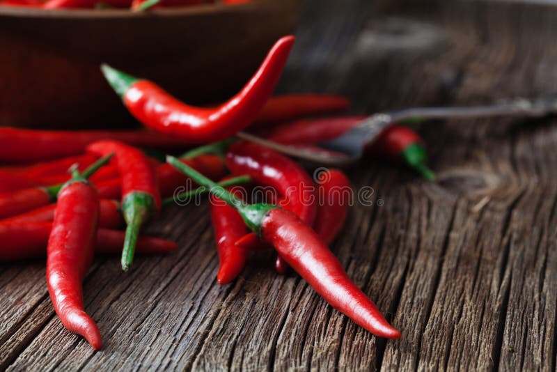 Накаленный докрасна перец chili на винтажной серебряной вилке над красной предпосылкой стоковые изображения rf Накаленный докрасна перец chili на винтажной серебряной вилке над красной предпосылкой стоковые изображения rf