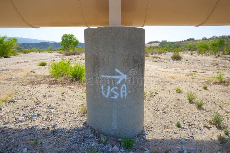 Spray painted sign on an aging pipeline points directions to Mexican migrants on the edge of the desert. Spray painted sign on an aging pipeline points directions to Mexican migrants on the edge of the desert.