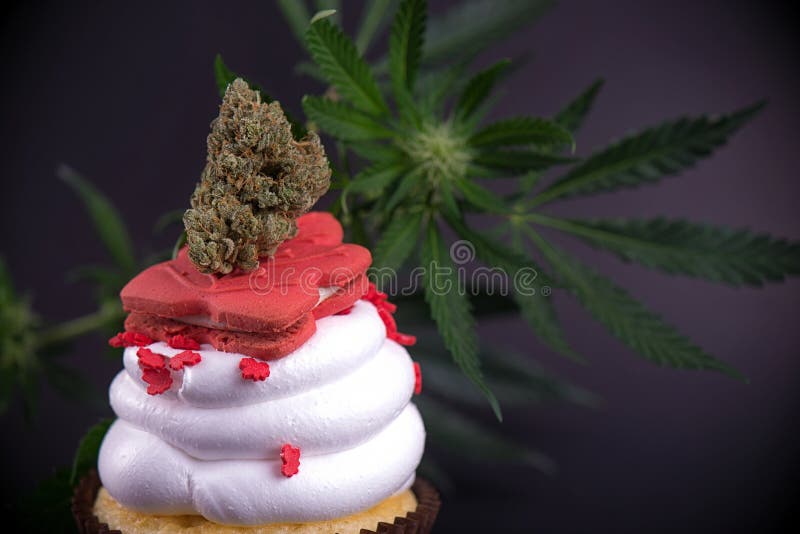 Настоянное пирожное с nug, цветками и флагом конопли, который нужно отпраздновать стоковое фото rf Настоянное пирожное с nug, цветками и флагом конопли, который нужно отпраздновать стоковое фото rf