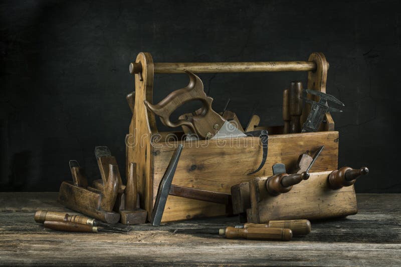Натюрморт - старый деревянный винтажный toolbox с молотками, пилой, зубилами, самолетом и плоскогубцами в плотничестве стоковое изображение rf Натюрморт - старый деревянный винтажный toolbox с молотками, пилой, зубилами, самолетом и плоскогубцами в плотничестве стоковое изображение rf