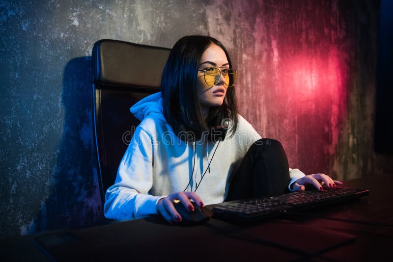 Наушники gamer девушки нося играя игры сети подготавливая участвовать в международных конкуренциях в esports стоковые фото Наушники gamer девушки нося играя игры сети подготавливая участвовать в международных конкуренциях в esports стоковые фото