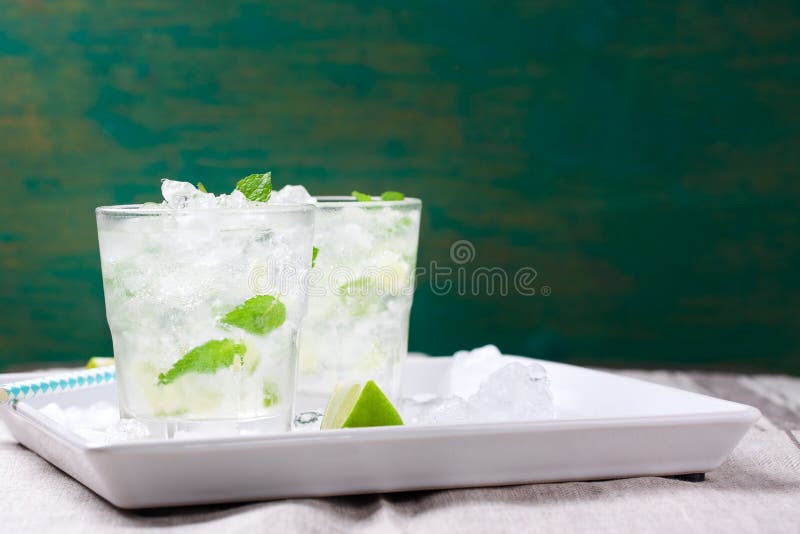 Не коктеиль mojito спирта холодный с свежей известкой, мятой и задавленным льдом на белой плите на винтажной деревянной предпосыл стоковые фото Не коктеиль mojito спирта холодный с свежей известкой, мятой и задавленным льдом на белой плите на винтажной деревянной предпосыл стоковые фото