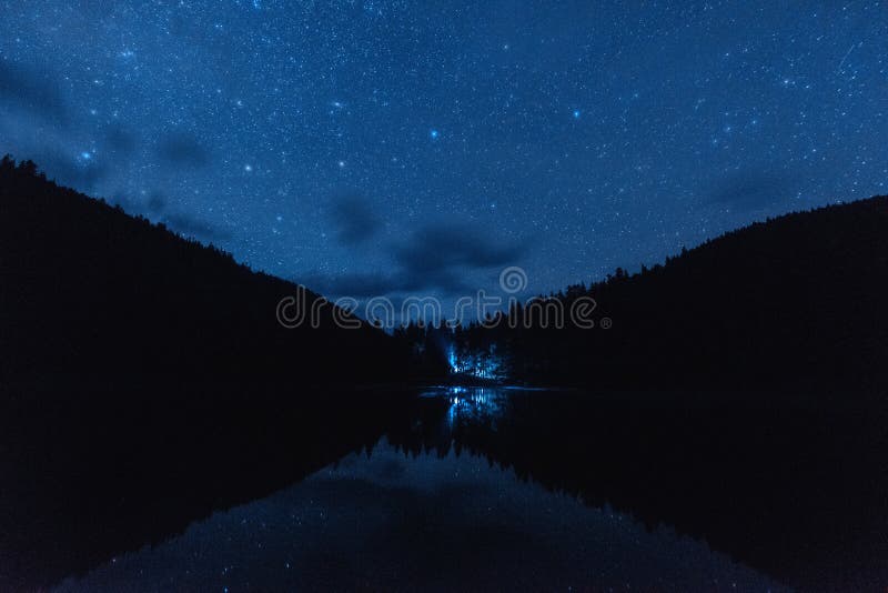 Небо ночи звездное с серией сияющих звезд во время метеорного потока Perseid над высокогорным озером Synevyr в прикарпатских гора стоковое фото Небо ночи звездное с серией сияющих звезд во время метеорного потока Perseid над высокогорным озером Synevyr в прикарпатских гора стоковое фото