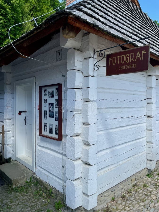 Небольшое белое здание с красным знаком, на котором написано стоковое фото