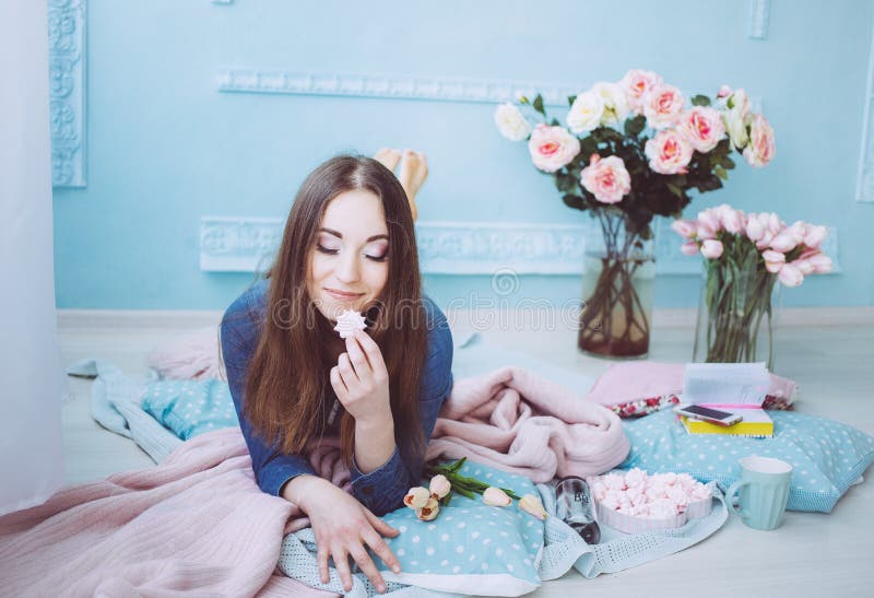 Нежная девушка лежа на поле, есть macarons Цветки тюльпана на голубом утре предпосылки стены весной стоковая фотография rf Нежная девушка лежа на поле, есть macarons Цветки тюльпана на голубом утре предпосылки стены весной стоковая фотография rf