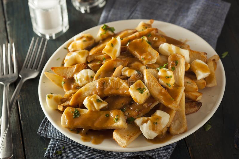 Нездоровое очень вкусное Poutine с французскими фраями стоковые изображения rf Нездоровое очень вкусное Poutine с французскими фраями стоковые изображения rf