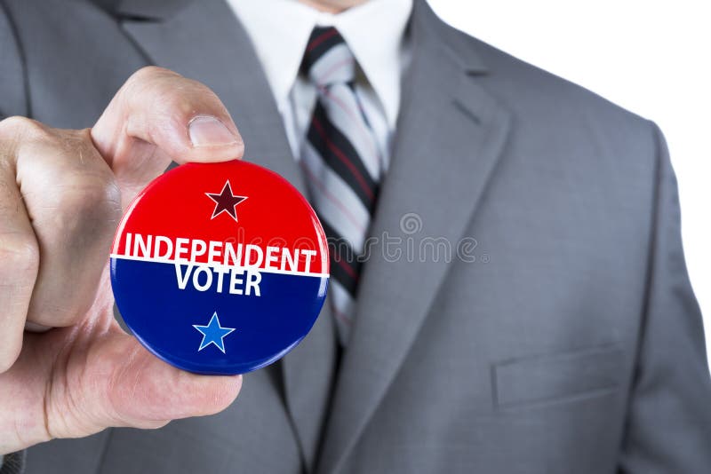 A man in a business suit holds out a political independent voter pin during elections. A man in a business suit holds out a political independent voter pin during elections.