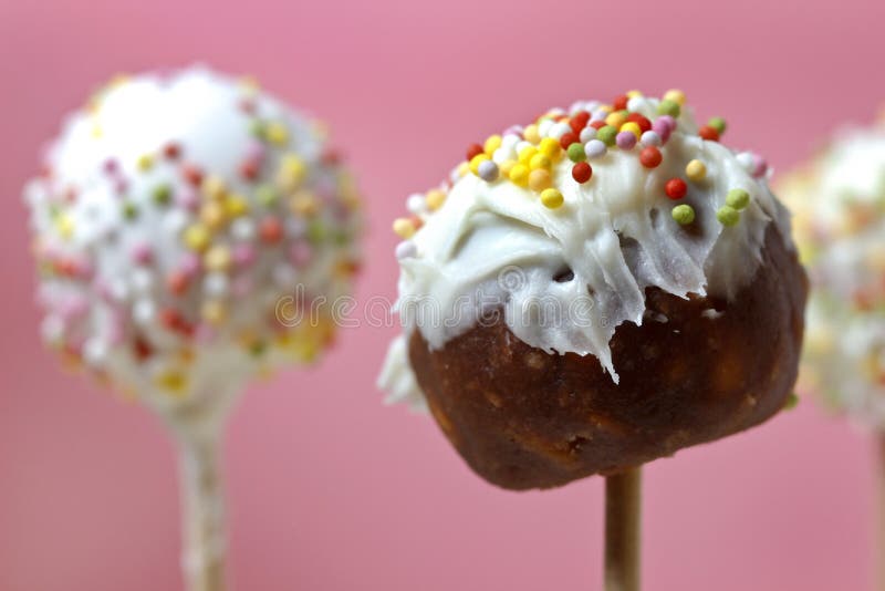 Unfinished cake pops decorated with sprinkles on pink background. Party dessert. Unfinished cake pops decorated with sprinkles on pink background. Party dessert