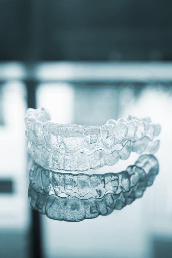 Незримые зубоврачебные стопорные устройства расчалок aligners кронштейнов зубов стоковые фотографии rf Незримые зубоврачебные стопорные устройства расчалок aligners кронштейнов зубов стоковые фотографии rf