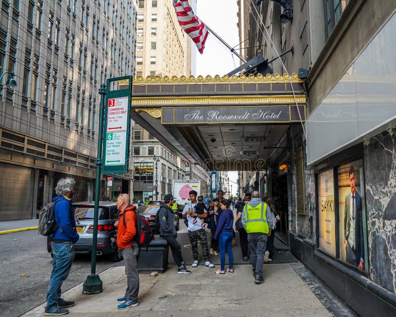 NEW YORK - MAY 23, 2023: Unidentified migrants in front of New York City's new migrant welcome center at the former four-star Roosevelt Hotel in Midtown Manhattan. It opened to accommodate an anticipated influx of asylum seekers. NEW YORK - MAY 23, 2023: Unidentified migrants in front of New York City's new migrant welcome center at the former four-star Roosevelt Hotel in Midtown Manhattan. It opened to accommodate an anticipated influx of asylum seekers