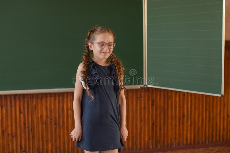 Немногое положение школьницы на классн классном Школьница с 2 отрезками провода в стеклах стоковая фотография rf
