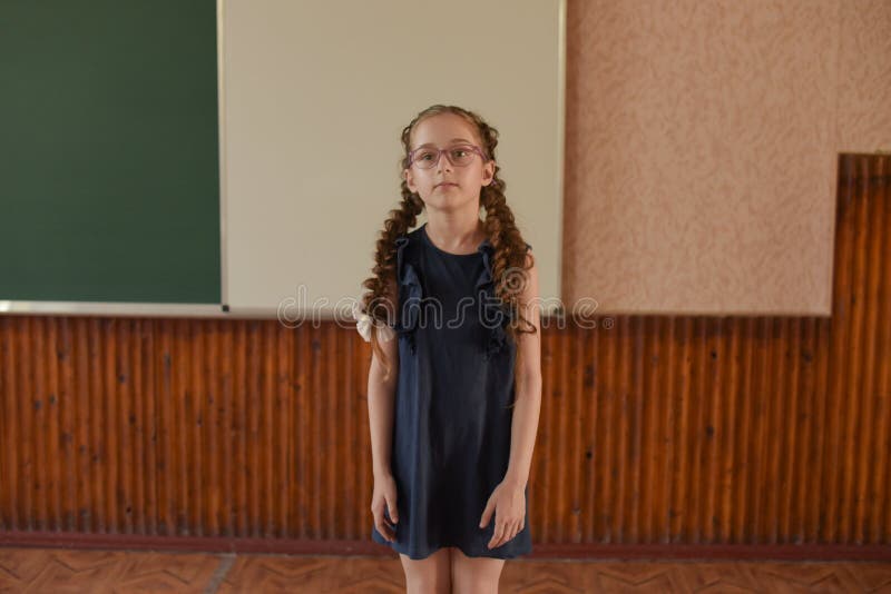 Немногое положение школьницы на классн классном Школьница с 2 отрезками провода в стеклах стоковое фото