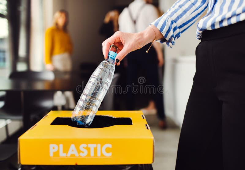 A concept of waste separation and recycling in business office, a midsection. A concept of waste separation and recycling in business office, a midsection.