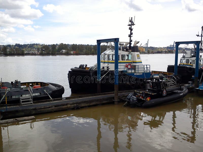 New Westminster Police boats and tugboats on the Fraser River, British Columbia, Canada. New Westminster Police boats and tugboats on the Fraser River, British Columbia, Canada.