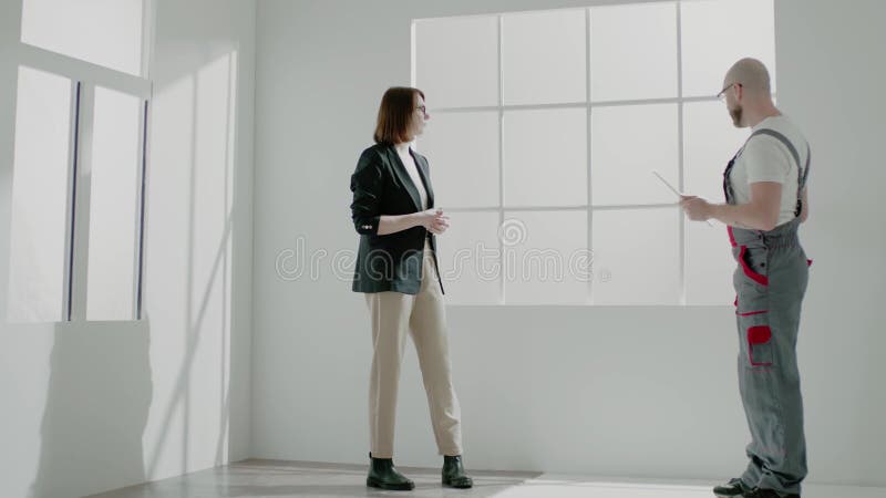 Новый владелец квартиры в очках, слушает лысый разнорабочего видеоматериал