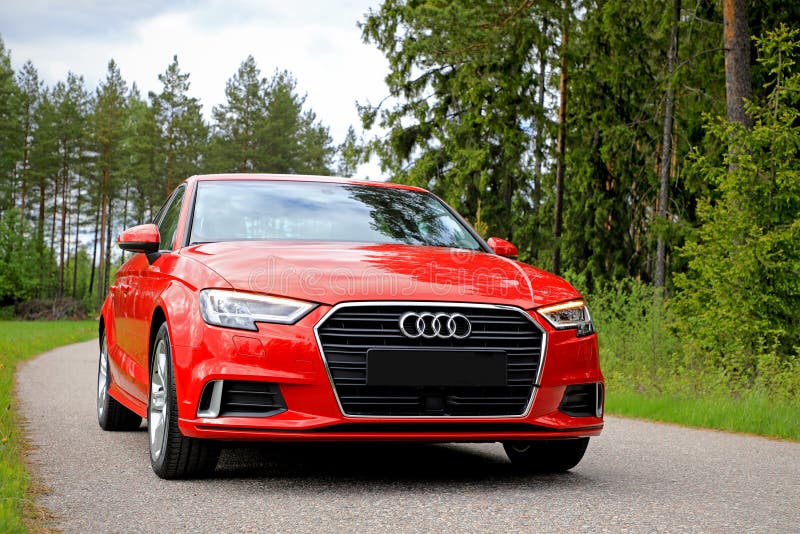 SALO, FINLAND - JUNE 2, 2017: New beautiful Tango red Audi A3 Sedan Business Sport 2017 parked on a small rural road flanked by forest in early summer. SALO, FINLAND - JUNE 2, 2017: New beautiful Tango red Audi A3 Sedan Business Sport 2017 parked on a small rural road flanked by forest in early summer.