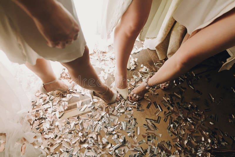 Ноги девушки в стильных белых ботинках, стоящ на золоте и серебряном confetti, bridal партия утра будуара перед свадебной церемон стоковая фотография Ноги девушки в стильных белых ботинках, стоящ на золоте и серебряном confetti, bridal партия утра будуара перед свадебной церемон стоковая фотография