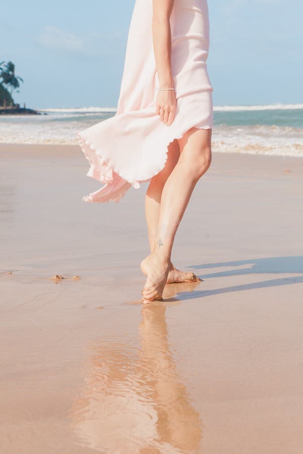 The woman legs walking on the beach sand. The woman legs walking on the beach sand