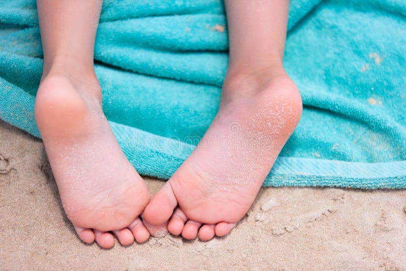 Close up of a little girl feet on a beach towel. Close up of a little girl feet on a beach towel