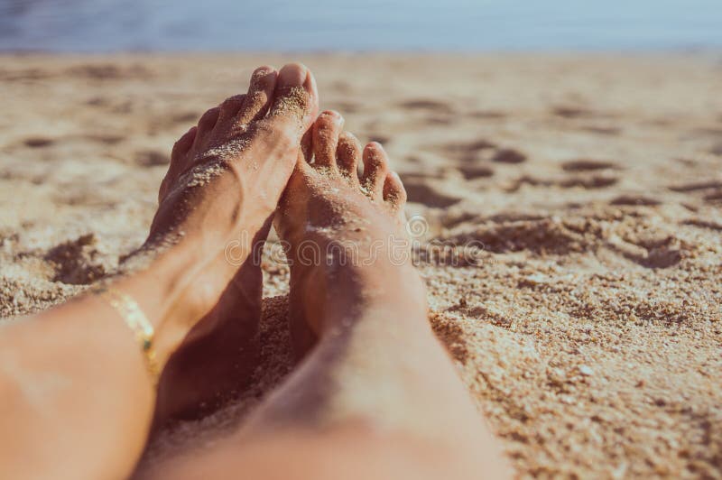 Woman legs on sand beach with small depth of field. Woman legs on sand beach with small depth of field