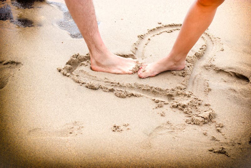 Couple's legs on beach sand - closeup. Couple's legs on beach sand - closeup