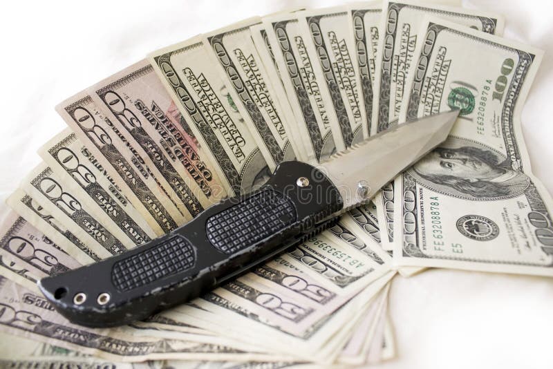 A knife and some fanned out cash laying on a bed. This works for all sorts of illegal activities such as prostitution, drug dealing, and gang activity. A knife and some fanned out cash laying on a bed. This works for all sorts of illegal activities such as prostitution, drug dealing, and gang activity.