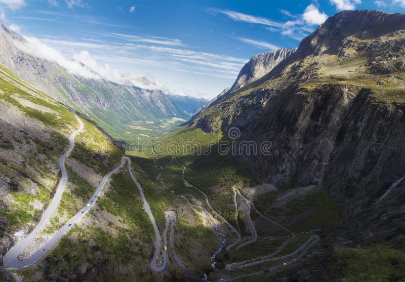 Trollstigen (English: Trolls' Path[1]) is a serpentine mountain road in Rauma Municipality, Møre og Romsdal county, Norway. It is part of Norwegian County Road 63 that connects the town of Åndalsnes in Rauma and the village of Valldal in Norddal Municipality. It is a popular tourist attraction due to its steep incline of 10% and eleven hairpin bends up a steep mountainside. During the top tourist season, about 2,500 vehicles pass daily.[2][3] During the 2012 season, 161,421 vehicles traversed the route, compared to 155,230 vehicles during 2009.[4] The road is narrow with many sharp bends, and although several bends were widened during 2005 to 2012,[5] vehicles over 12.4 metres (41 ft) long are prohibited from driving the road. During the 2011 and 2012 seasons, buses up to 13.1 metres (43 ft) were temporarily allowed as a trial.[6][7] At the 700-metre (2,300 ft) plateau there is a car park and several viewing balconies overlooking the bends and the Stigfossen waterfall. Stigfossen falls 320 metres (1,050 ft) down the mountainside. The pass has an elevation of approximately 850 metres (2,790 ft). Trollstigen is closed during late autumn and winter. A normal operating season stretches from mid-May to October, but may sometimes be shorter or longer due to weather conditions. Trollstigen (English: Trolls' Path[1]) is a serpentine mountain road in Rauma Municipality, Møre og Romsdal county, Norway. It is part of Norwegian County Road 63 that connects the town of Åndalsnes in Rauma and the village of Valldal in Norddal Municipality. It is a popular tourist attraction due to its steep incline of 10% and eleven hairpin bends up a steep mountainside. During the top tourist season, about 2,500 vehicles pass daily.[2][3] During the 2012 season, 161,421 vehicles traversed the route, compared to 155,230 vehicles during 2009.[4] The road is narrow with many sharp bends, and although several bends were widened during 2005 to 2012,[5] vehicles over 12.4 metres (41 ft) long are prohibited from driving the road. During the 2011 and 2012 seasons, buses up to 13.1 metres (43 ft) were temporarily allowed as a trial.[6][7] At the 700-metre (2,300 ft) plateau there is a car park and several viewing balconies overlooking the bends and the Stigfossen waterfall. Stigfossen falls 320 metres (1,050 ft) down the mountainside. The pass has an elevation of approximately 850 metres (2,790 ft). Trollstigen is closed during late autumn and winter. A normal operating season stretches from mid-May to October, but may sometimes be shorter or longer due to weather conditions.