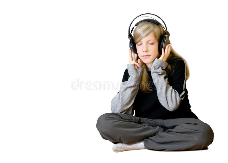 Girl listening to music while sitting om the floor. Isolated on white background. Girl listening to music while sitting om the floor. Isolated on white background.