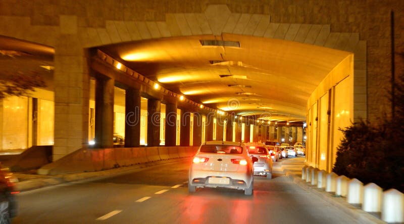 Cars are passing through beautiful gold lightened highway tunnel at night. Jerusalem. Israel. The left side of picture can be used for your text. Cars are passing through beautiful gold lightened highway tunnel at night. Jerusalem. Israel. The left side of picture can be used for your text.