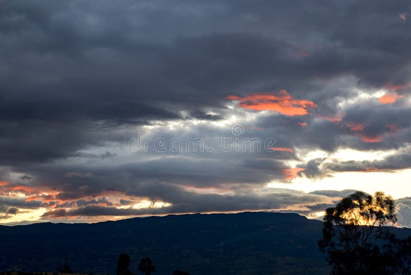 Multiple exposure of little clouds lightened by the red sunbeams of sunset. At the Andean mountains of central Colombia. Multiple exposure of little clouds lightened by the red sunbeams of sunset. At the Andean mountains of central Colombia