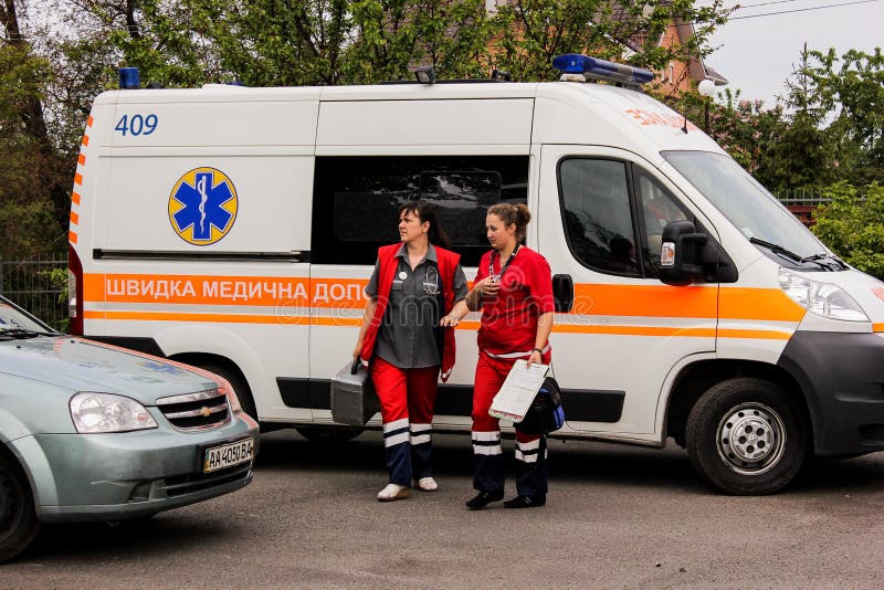ОБЛАСТЬ КИЕВА, УКРАИНА - 12-ое мая 2016: машина скорой помощи и медсестра на улице Машина скорой помощи около больницы стоковые изображения ОБЛАСТЬ КИЕВА, УКРАИНА - 12-ое мая 2016: машина скорой помощи и медсестра на улице Машина скорой помощи около больницы стоковые изображения