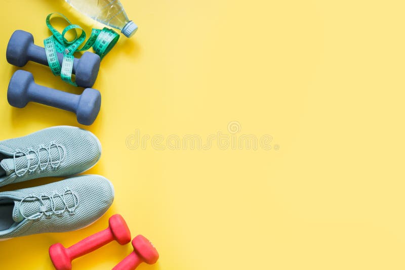 Оборудование спорта и фитнеса, гантели, ботинки фитнеса, измеряя лента на напористом желтом цвете r стоковое изображение rf Оборудование спорта и фитнеса, гантели, ботинки фитнеса, измеряя лента на напористом желтом цвете r стоковое изображение rf