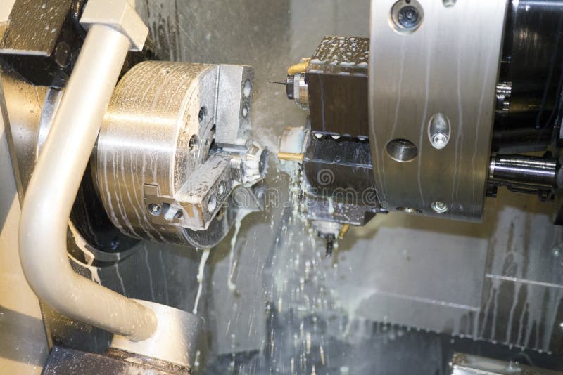 Обрабатывать деталь на токарном станке CNC с хладоагентом стоковое фото rf Обрабатывать деталь на токарном станке CNC с хладоагентом стоковое фото rf